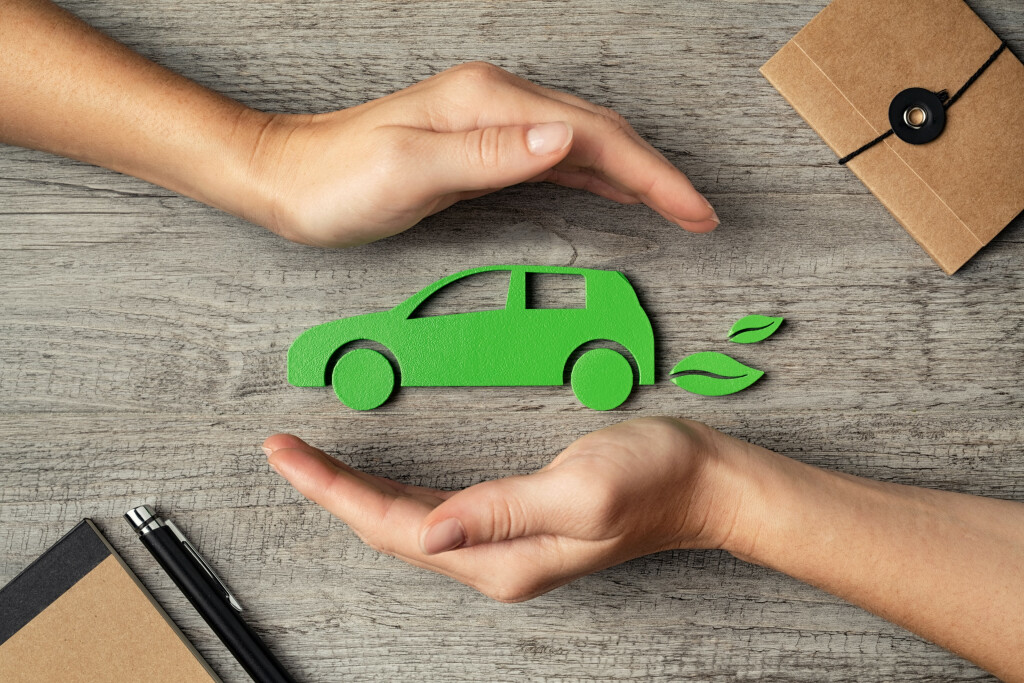 Grünes Auto von Händen umrundet.
