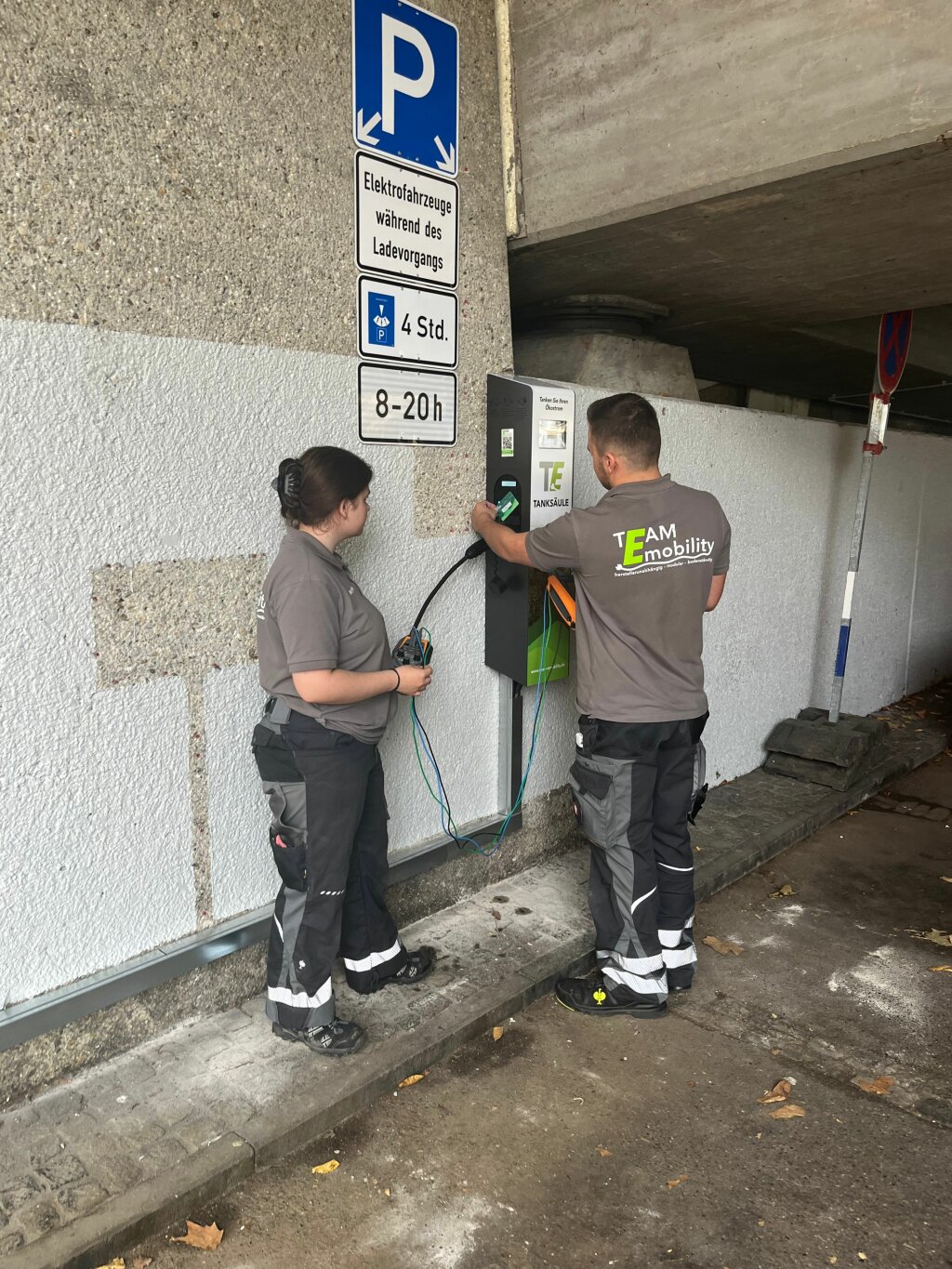 Zwei Techniker konfigurieren eine öffentlichen Wallbox.